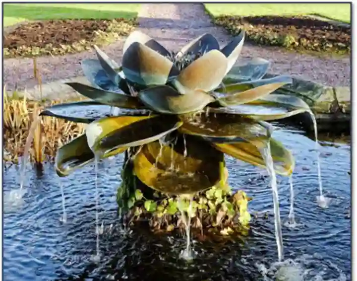 Water fountain with water dripping from metal leaves.