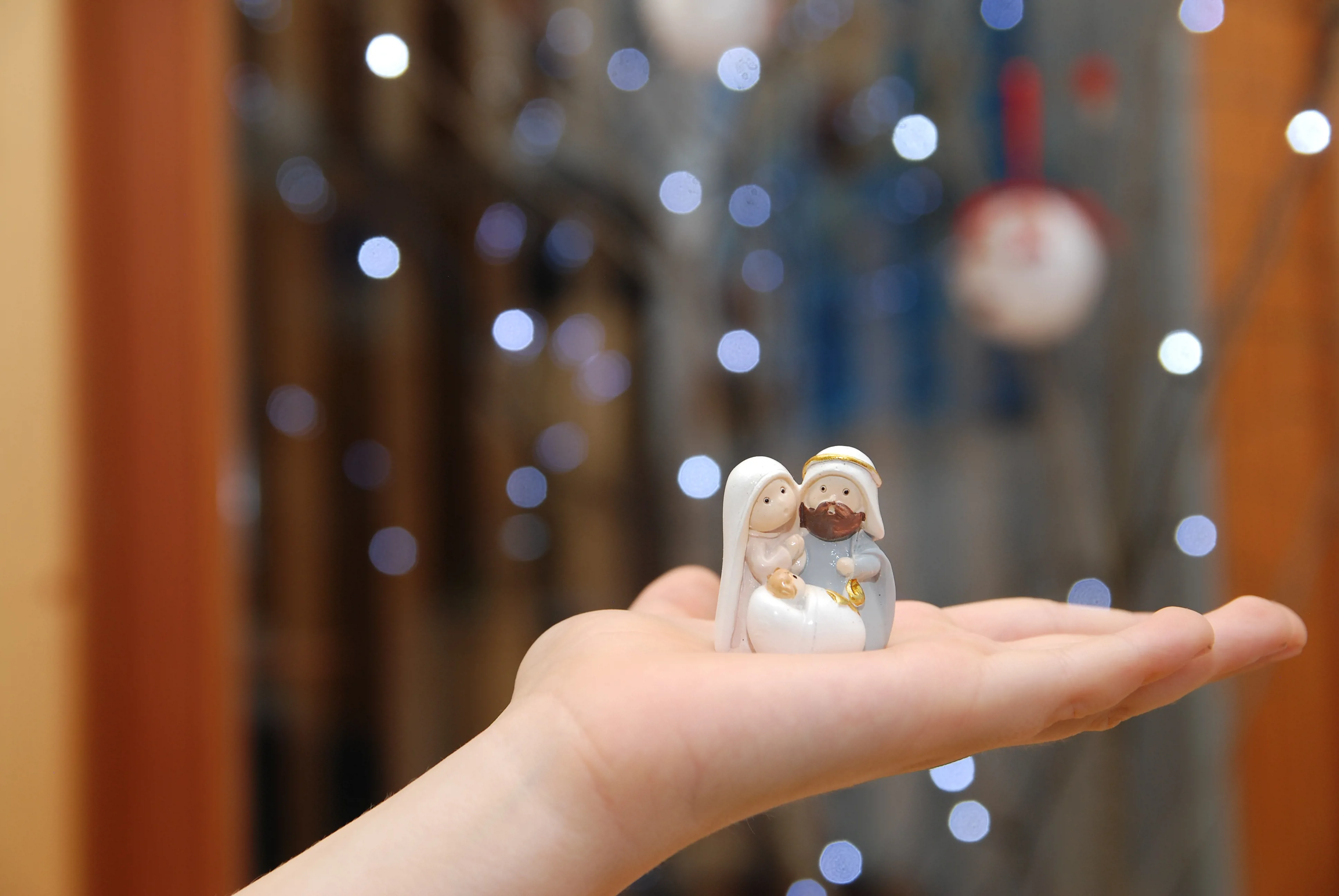 Child's open hand with ceramic nativity figures