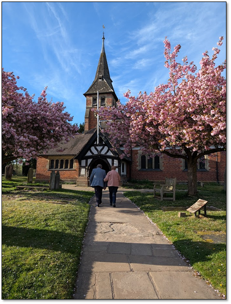 Whitegate Church on a spring day with people strolling up the path