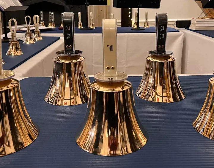 A photo of brass handbells laid out on a table
