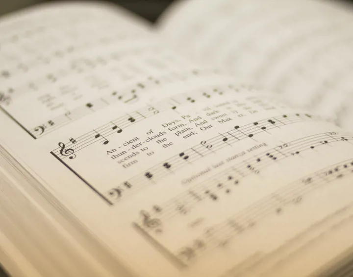 An open hymn book with musical score
