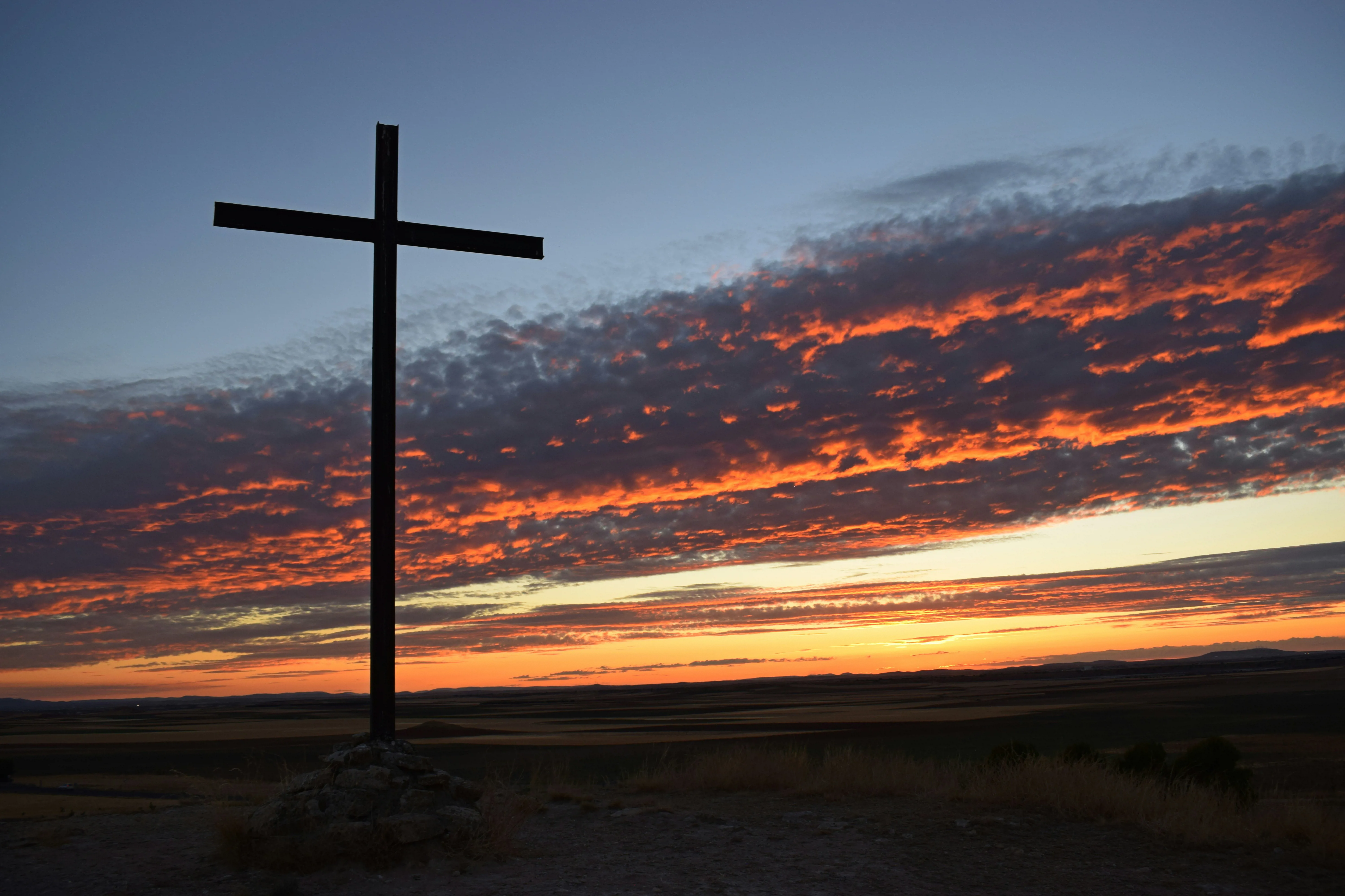 A cross with a sunset sky behind