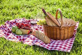 Picnic food set out on a table cloth on grass