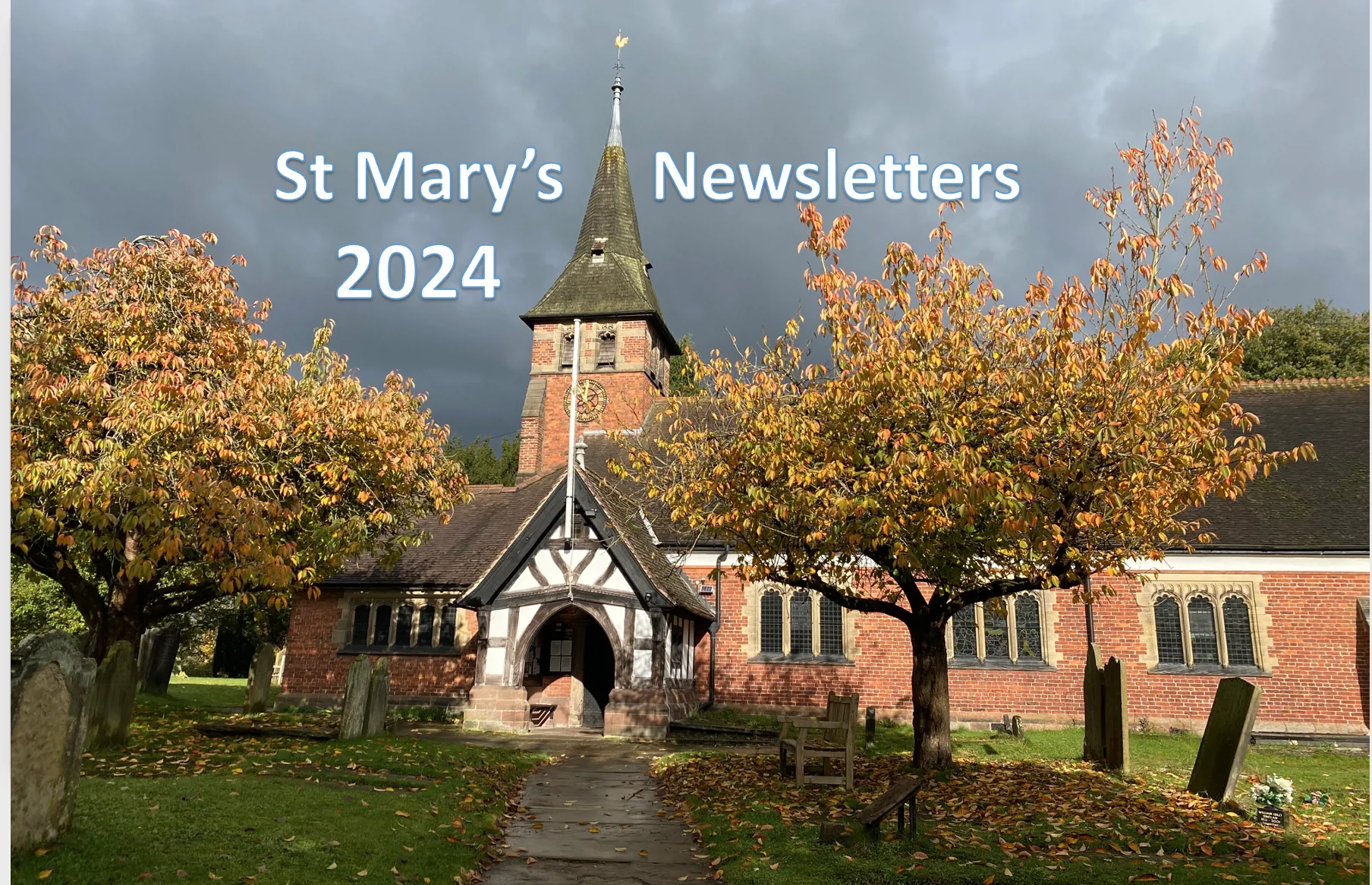 Photo of St Mary's church in autumn with sunshine, a dark sky and fallen leaves