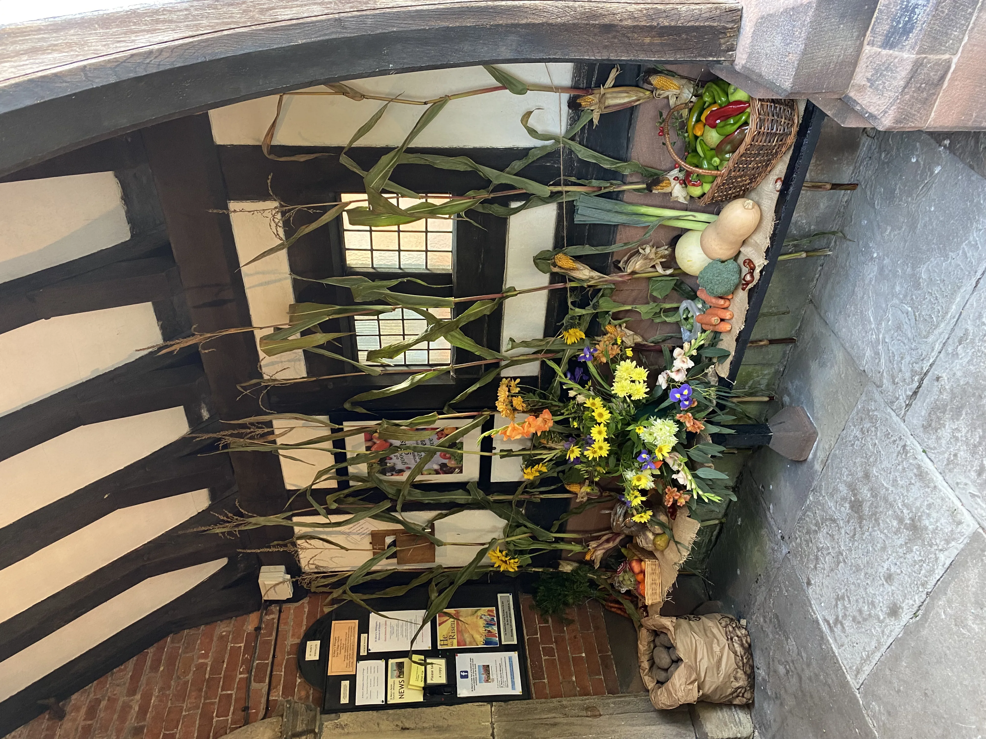 Church porch decorated with fruit and vegetables for Harvest Festival.